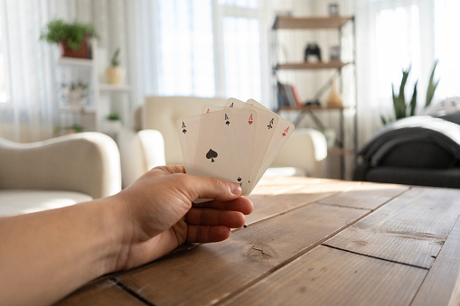 Man hand holding playing cards at home