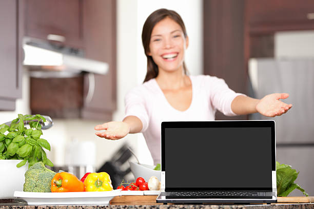istock Woman cooking showing laptop in kitchen 178573452