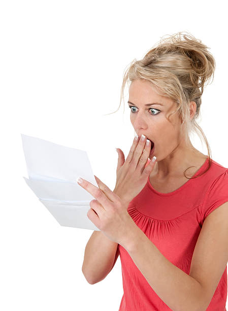 shocked blond woman getting letter with bad news and having hand in front of mouth