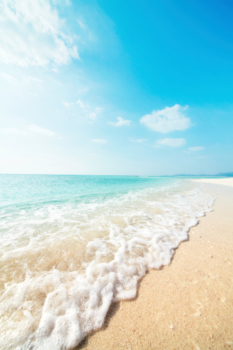 Waves lap on sandy beach, in springtime