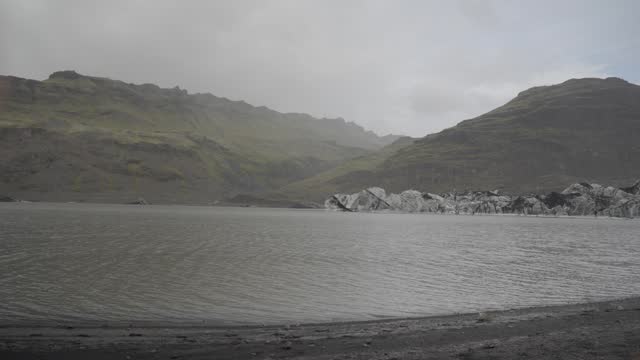 Misty Icelandic lake with rugged mountains evoking loneliness