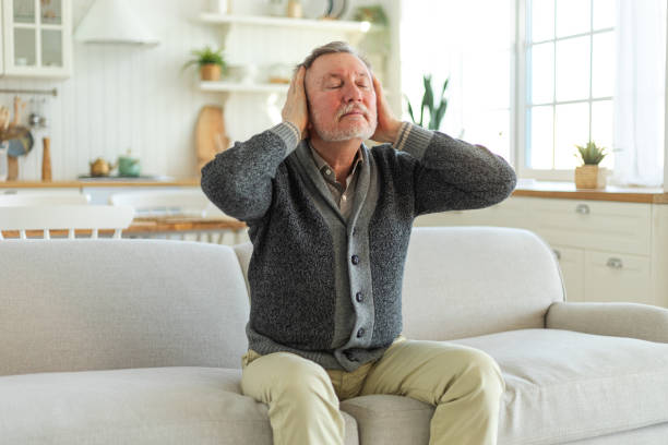 istock Headache pain. Unhappy middle aged senior man suffering from headache sick rubbing temples at home. Mature old senior grandfather touching temples experiencing stress. Man feeling pain hurt in head. 1785767964