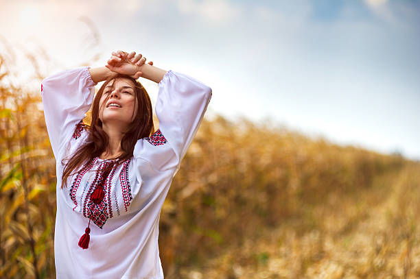 istock Woman in traditional shirt standing on cornfield 178577650