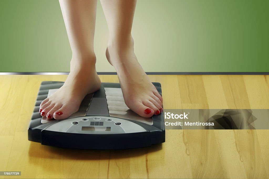 Woman standing on scales Adult Stock Photo