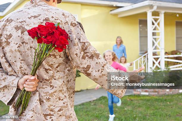 Family Welcoming Husband Home On Army Leave Stock Photo - Download Image Now - 30-39 Years, 4-5 Years, 8-9 Years