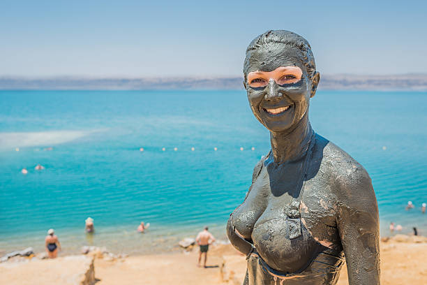 one caucasian woman applying dead sea mud body care treatment  in jordan
