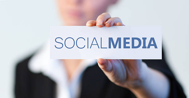 Businesswoman holding a label with social media written on it with focus on the hand