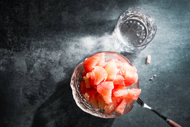 Sunlight shining on grapefruits with red flesh placed on a slate board in a bowl