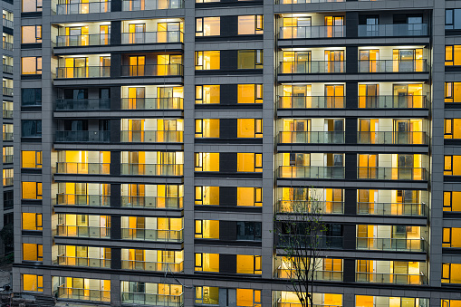 Modern residential building filled with lights in the early morning.