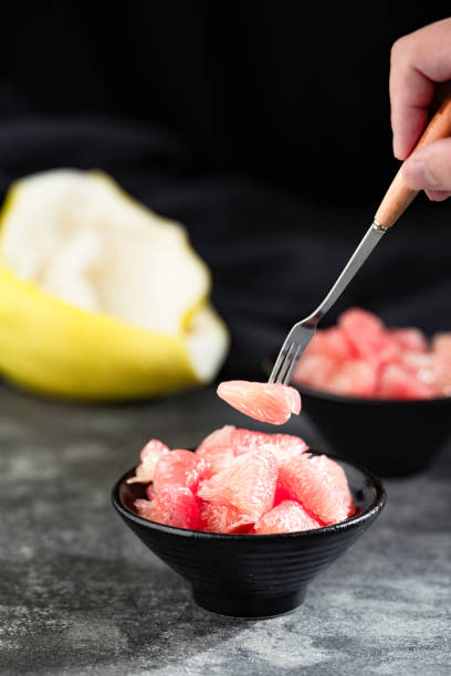 Sunlight shining on grapefruits with red flesh placed on a slate board in a bowl