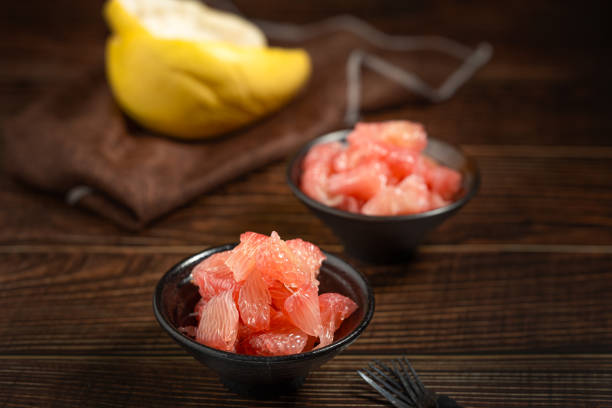 istock Grapefruits with red flesh placed on a wooden board in a bowl. 1785794425