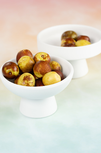 Green dates placed on a background board and served in a bowl.