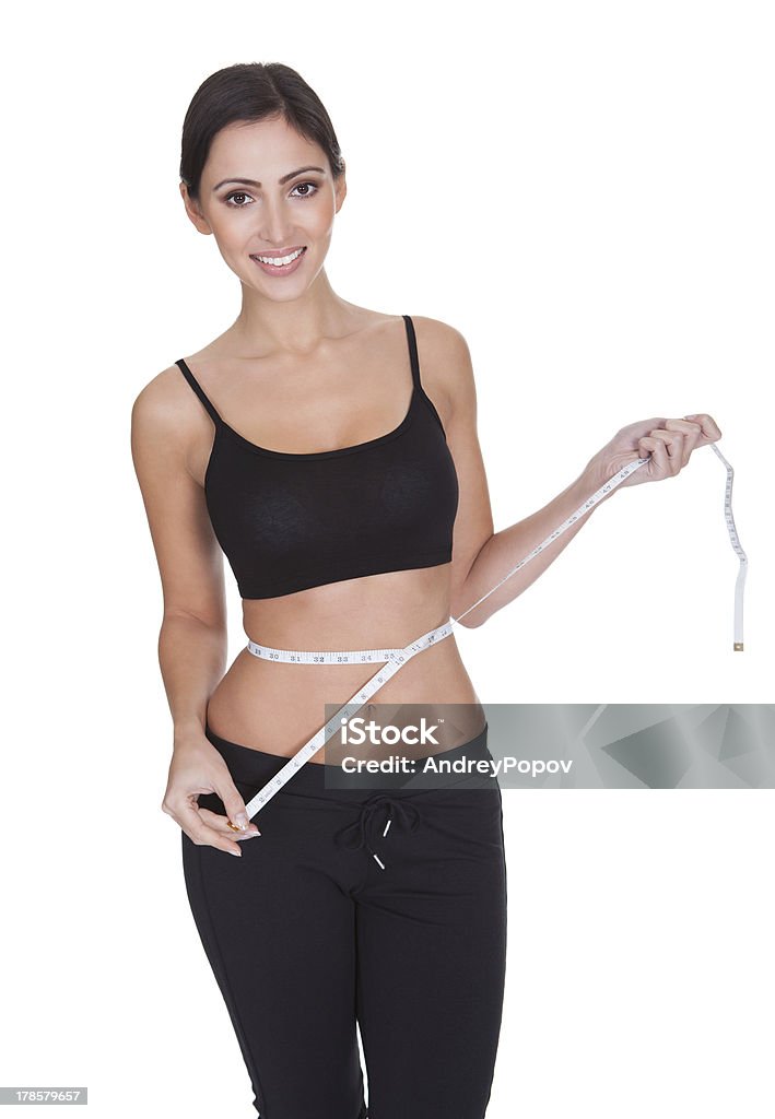 Fit giovane donna misurando la sua vita - Foto stock royalty-free di Accudire