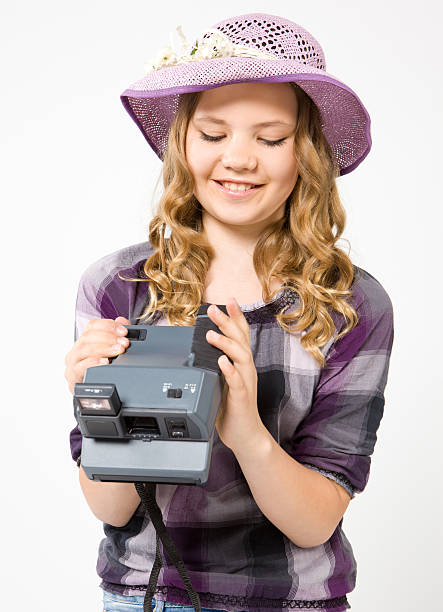 Smiling teenage girl holding a polaroid camera stock photo