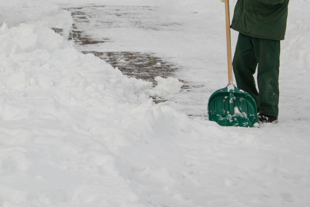 istock Man in uniform cleaning snow with a shovel 1785809869