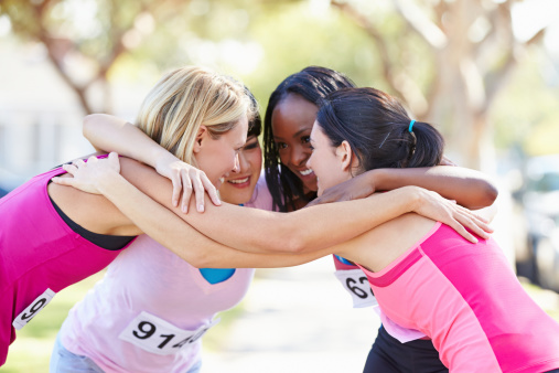 Female Runners Congratulating One Another After Race With Arms Round Each Other In A Circle