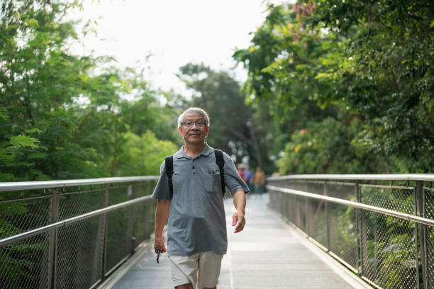 istock Asian old man hiking on footbridge in park 1785818045