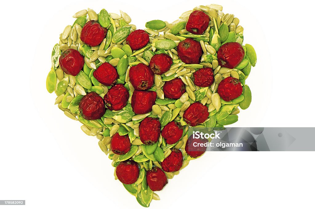 Healthy heart Pumpkin and sunflower seeds' kernel with dry haw forming heart shape on white background Berry Stock Photo