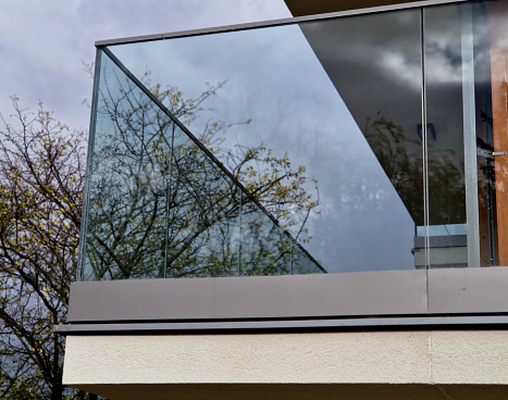 railing of a luxury house formed by glass panels fastened with metal stainless steel handles. gives an airy impression. polished metal cover on a greenhouse terrace window, reflection, flower, pink, block of flats