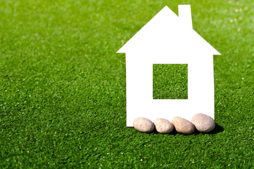 cardboard house with stones against the green grass