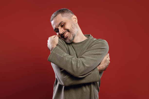 istock smiling man hugging himself with eyes closed 1785839191