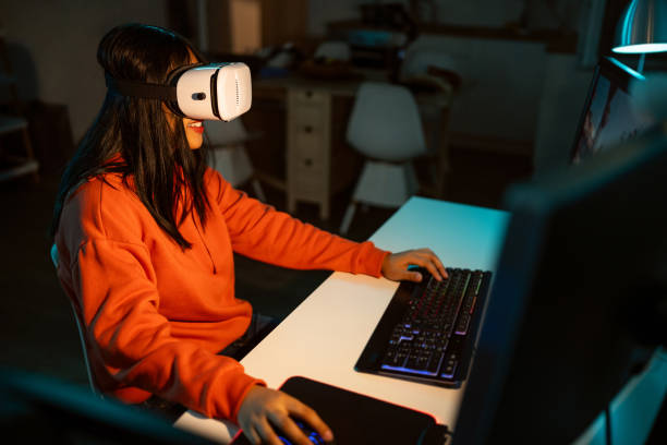 istock Female gamer Asian ethnicity wear VR headset while playing video game on PC 1785839537