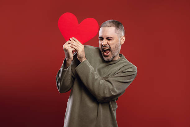 istock happy man holding a paper heart with both hands 1785840351