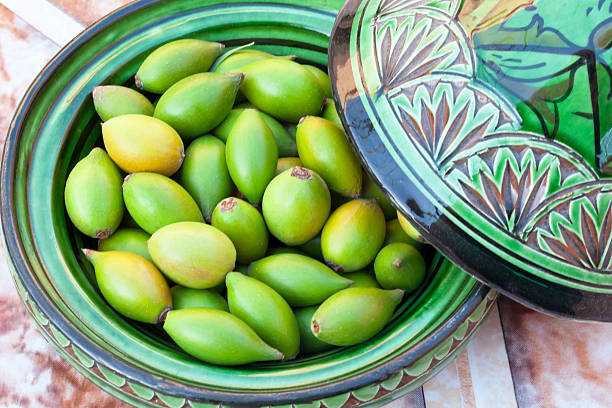 Argan nuts in a green plate. stock photo