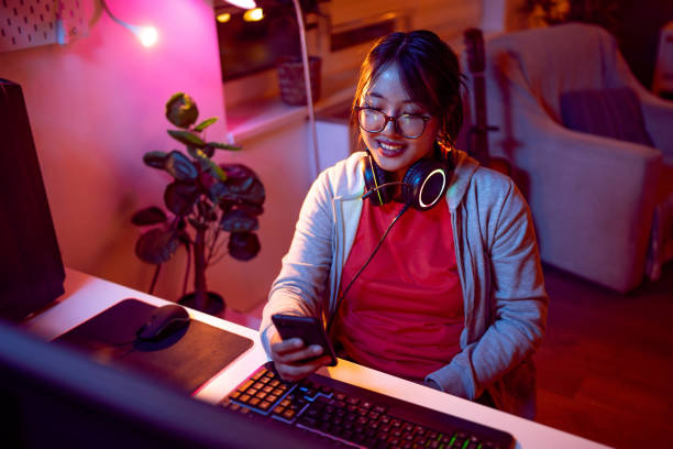istock Female gamer Asian ethnicity using mobile phone 1785842649