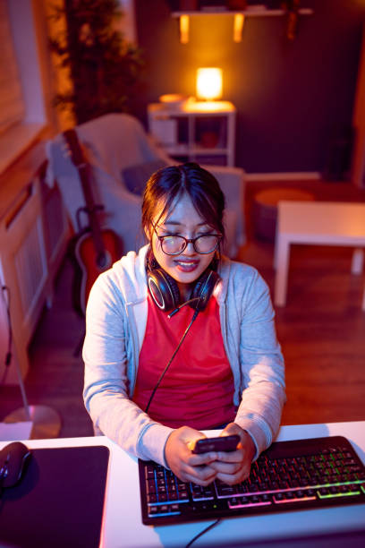 istock Female gamer Asian ethnicity using mobile phone 1785842658