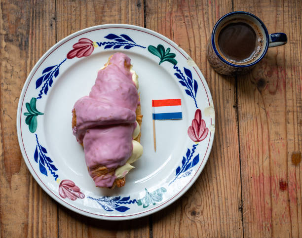 un crompouce con bandiera olandese e un caffè.  un incrocio tra un tompouce e un croissant originario dei paesi bassi - tompouce foto e immagini stock