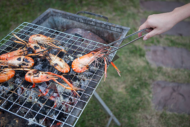istock shrimp on the grill with hand 178584538