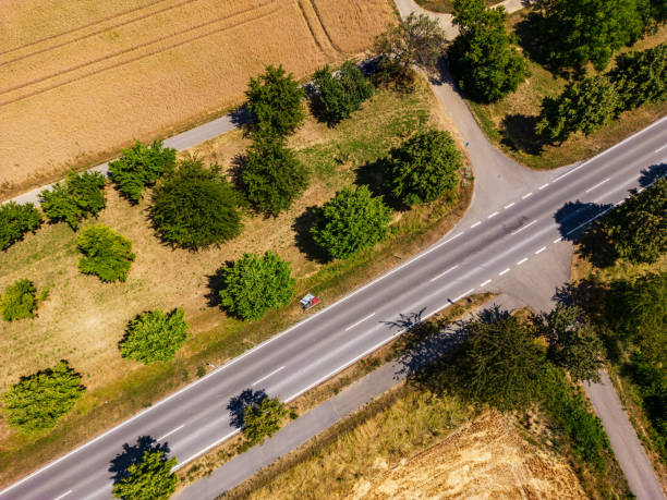 istock Road with cycle path crosses a dirt track in the countryside 1785848521