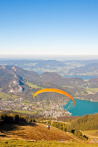 gleitschirmfliegen auf die berge und den see - paragliding sport austria parachuting stock-fotos und bilder