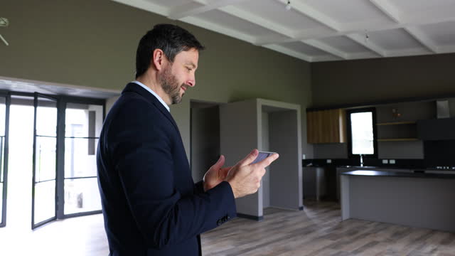 Real estate agent taking pictures of a beautiful modern property using a digital tablet