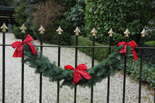 Classic steel fence decorated with a traditional christmas garland