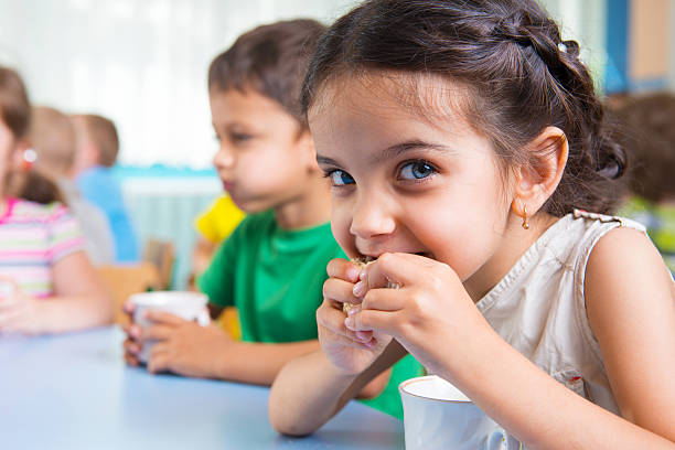 carino piccolo bambino bere latte - spuntino foto e immagini stock