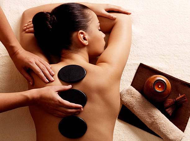 Woman getting hot stone massage in spa salon. Young woman getting hot stone massage in spa salon. Beauty treatment concept. hot stone massage stock pictures, royalty-free photos & images