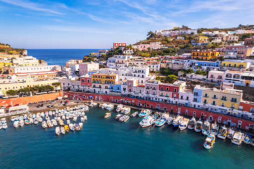 Drone shot of the village of Ponza, with colorful buildings sea front and the marina with boats, Ponza Island, Pontine archipelago, Tyrrhenian sea, Latina province, Latium, Italy
