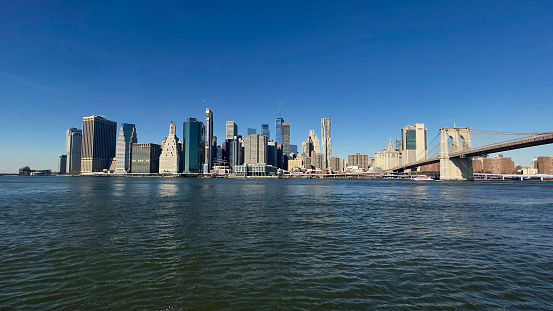 Panoramic view of Manhattan skyline shot from Brooklyn Bridge on a beautiful day in November of 2023