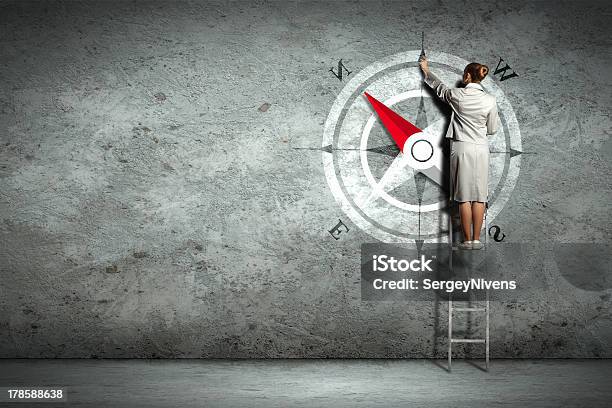 Businesswoman On A Ladder Drawing Compass On Wall Stock Photo - Download Image Now - Activity, Adult, Business