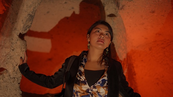 A multiracial female tourist is visiting an underground city in Cappadocia Türkiye Turkey during her travel.
