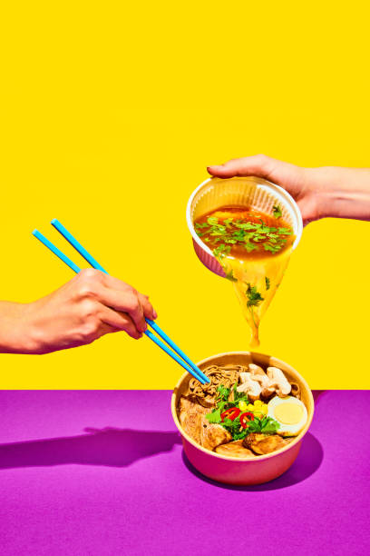 Stir-fry soba in trendy style. Hand pouring broth to fried noodles, Asian fried buckwheat noodles with chicken on vivid background.