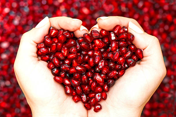 Pomegranate Seeds Shaping Heart In Hands Stock Photo - Download Image Now - Pomegranate, Heart Shape, Antioxidant - iStock