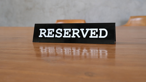 Reserved sign placard on the empty table in restaurant