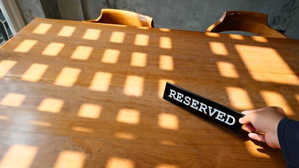 istock Waitress' hand placing reserved placard on the restaurant table 1785904323