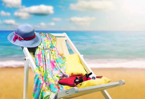 Hat and dress on deckchair at beach