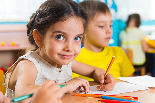 Group of cute little prescool kids drawing Group of cute little prescool kids drawing with colorful pencils preschool student stock pictures, royalty-free photos & images