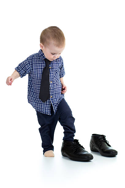 little boy trying on father shoes