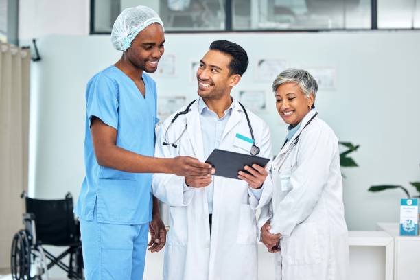 istock Group, doctors and nurse with a tablet, teamwork and connection with internet, conversation and network. Happy people, medical professionals and employees with technology, healthcare and planning 1785918609
